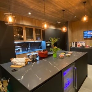 Cuisine sans poignées en Fenix noir avec un plan de travail en céramique, alliant élégance et matériaux haut de gamme