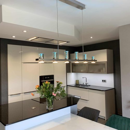 Cuisine laquée blanche brillante avec plan de travail en granit et table en verre