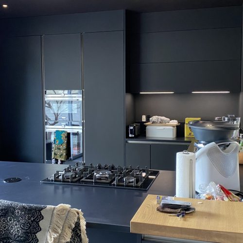 Cuisine noire mate avec électroménager et luminaires intégrés