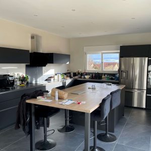 Îlot central bifonctionnel avec coin repas intégré dans une cuisine moderne équipée, alliant praticité et convivialité.