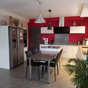 Cuisine laquée blanche brillante avec un plan de travail en quartz, alliant élégance et durabilité.