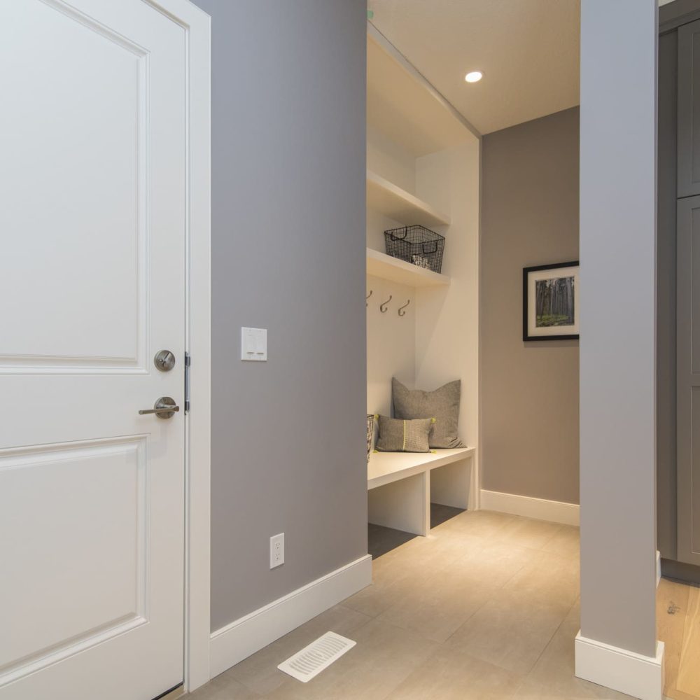 espace d’entrée de maison optimisé avec un aménagement sur mesure incluant rangements, assise et éléments décoratifs intégrés