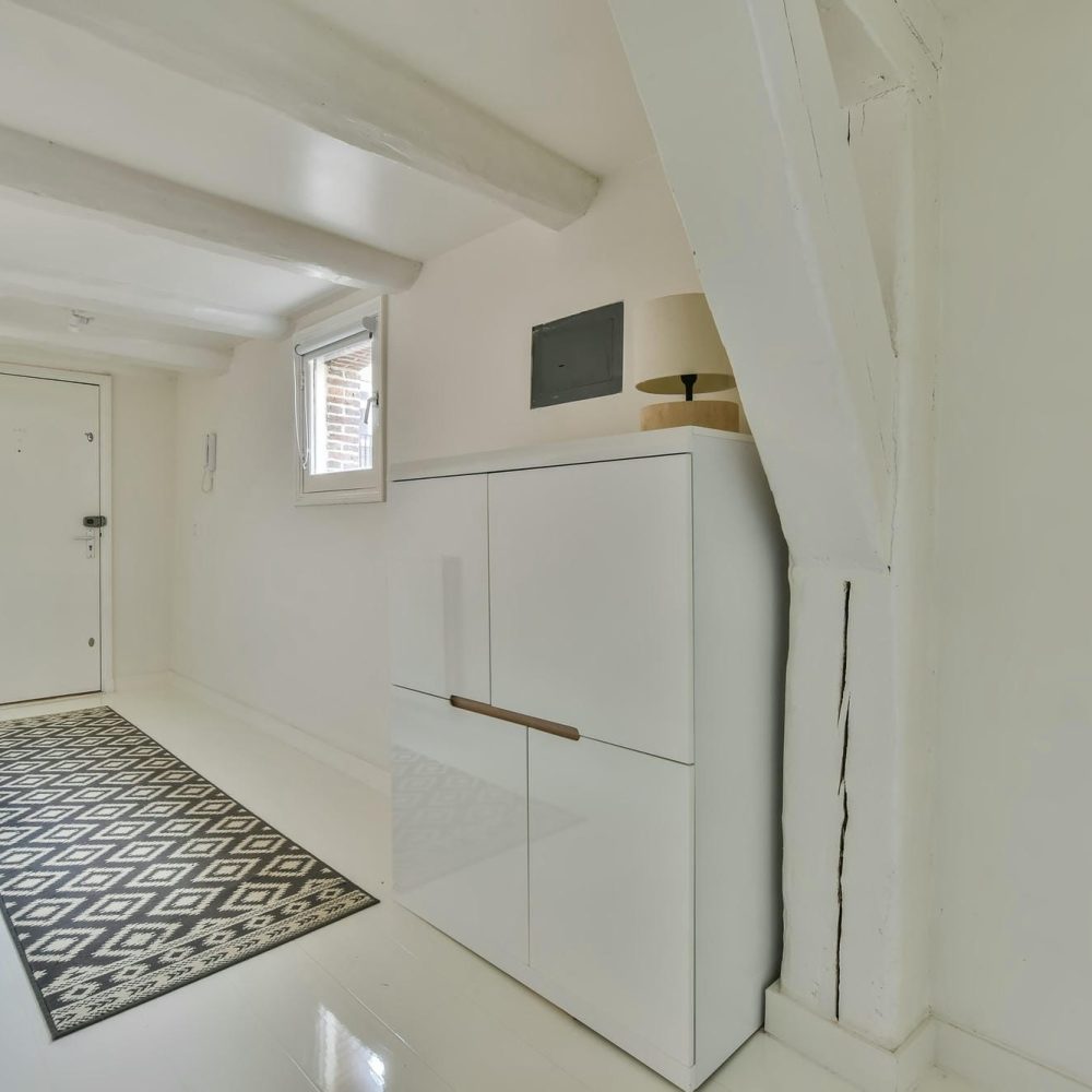 armoire blanche placée dans l’entrée d’une maison pour un rangement discret et élégant