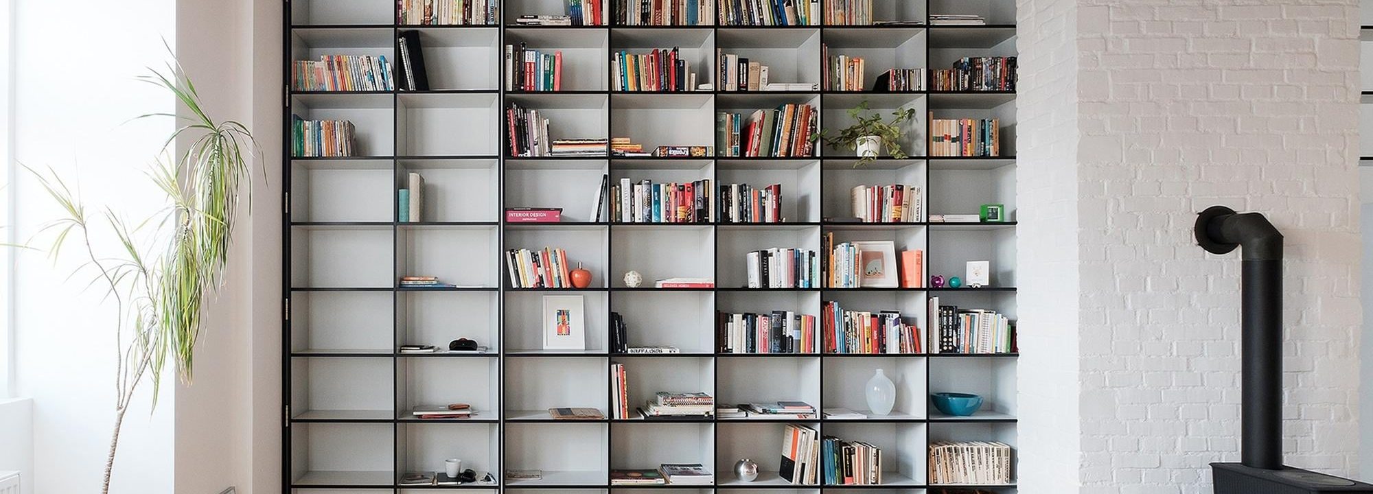 Bibliothèque en métal noir encastrée dans un recoin du salon pour un rangement discret et design