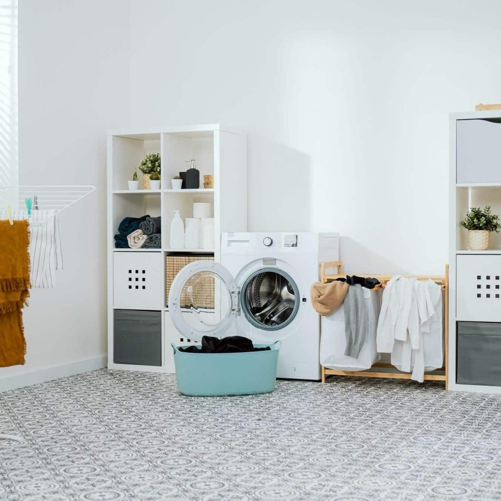 buanderie agencée avec meubles de rangement, plan de travail et électroménager intégré pour un usage quotidien optimisé