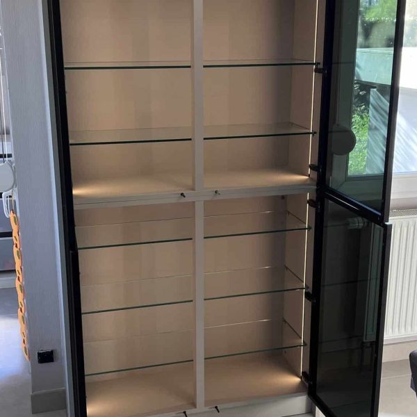Éclairage LED d’une vitrine à vitres noires intégrée dans une cuisine sur mesure