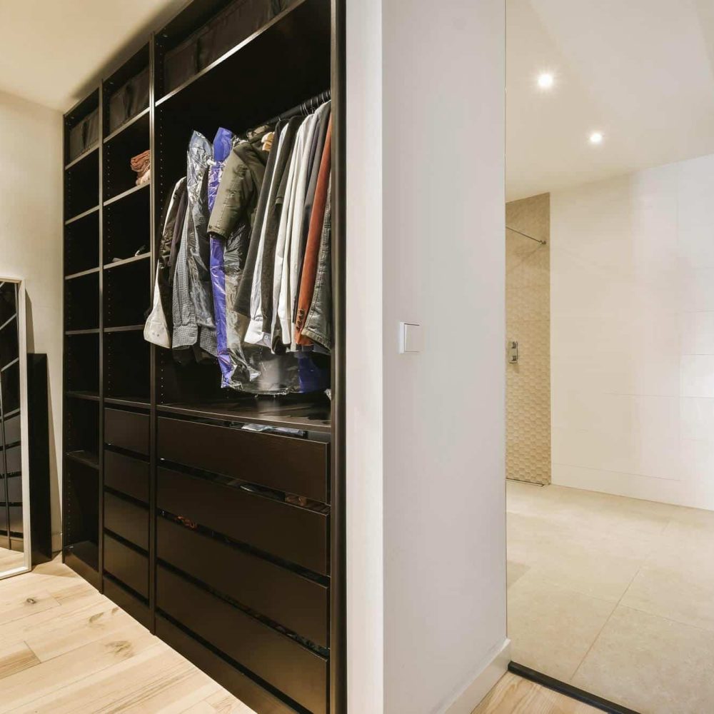 Dressing sur mesure aménagé dans une pièce attenante à la salle de bain pour un rangement pratique et élégant