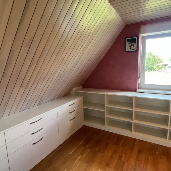 dressing sur-mesure installé sous une pente de toit optimisant l’espace disponible