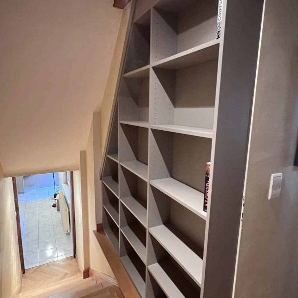Installation d’étagères sur mesure en bordure d’escalier, optimisant l’espace avec une solution de rangement élégante et fonctionnelle