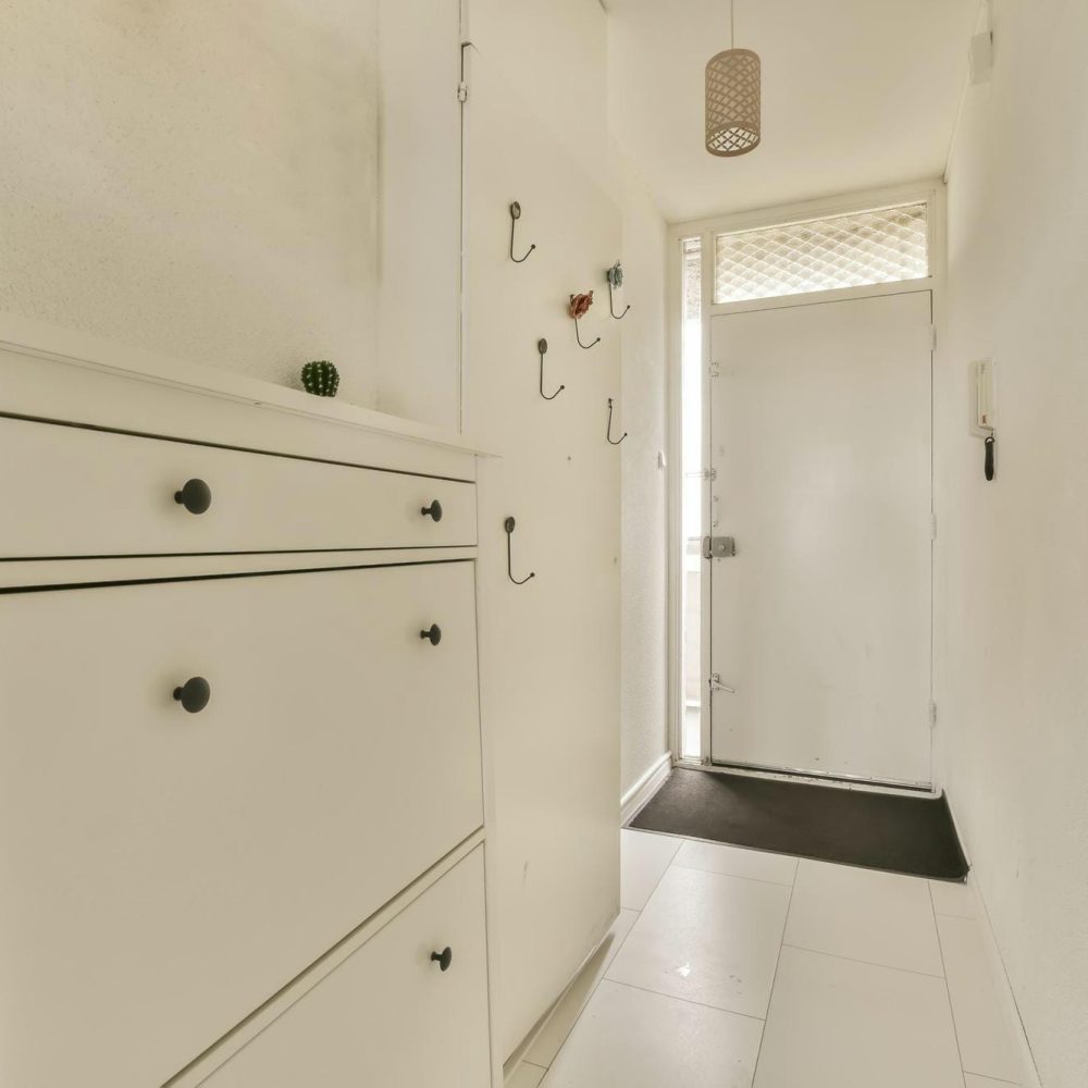 mobilier de rangement intégré dans l’entrée d’une maison avec étagères, placards et porte-manteaux fonctionnels