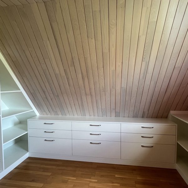 vue d’ensemble d’un dressing sur-mesure installé sous pente dans des combles aménagés